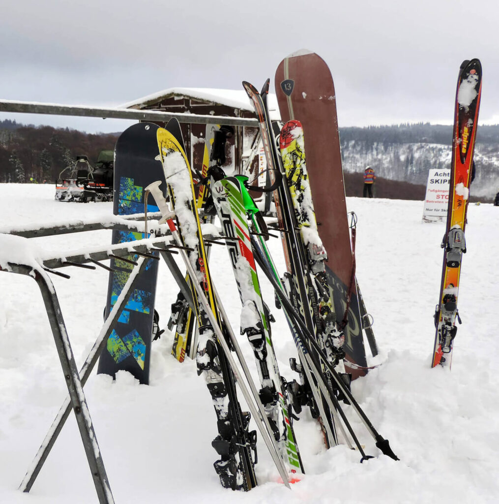 Abgestellte Ski und Snowboards auf einem Skihang im Sauerland